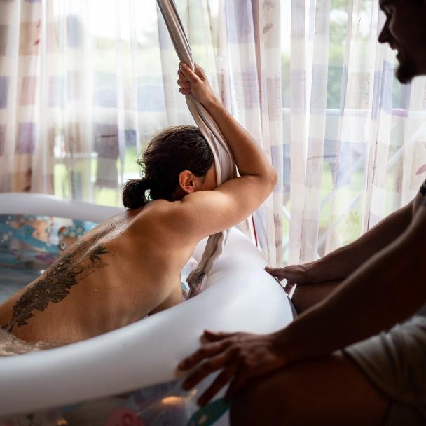 femme qui accouche dans une piscine d'accouchement à domicile